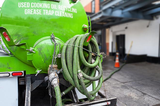 a grease trap pumping truck at a restaurant in Clay MI